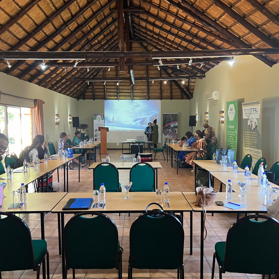 The thatched conference hall arranged with tables and projection equipment.