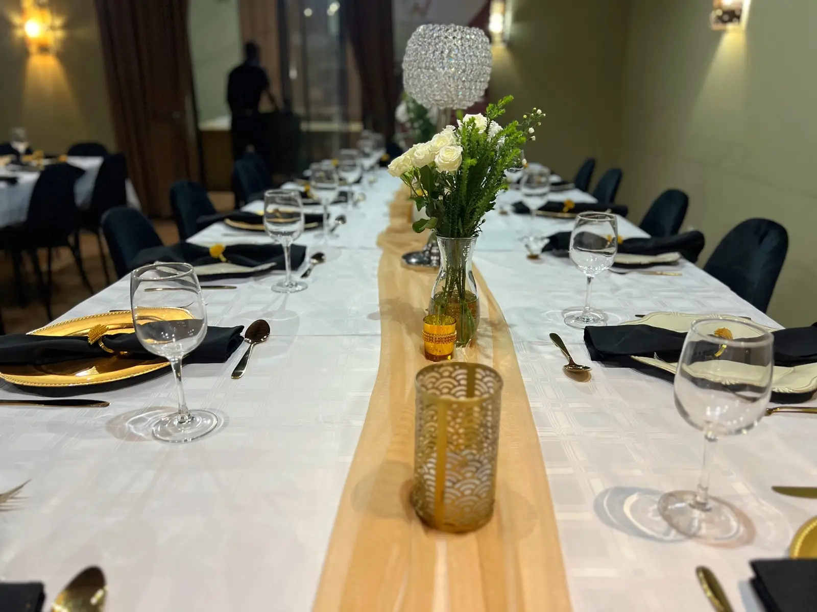 A private dining table dressed with linen, flowers and glassware.